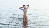 Tight babe reveals everything she got while playing around in the water, wearing nothing but her white shirt, which does not hide anything at all.