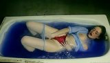Watch how a marvelous babe with a shaved pussy has it penetrated with an empty bottle, while lying down in a hot blue water, in her bathtub.