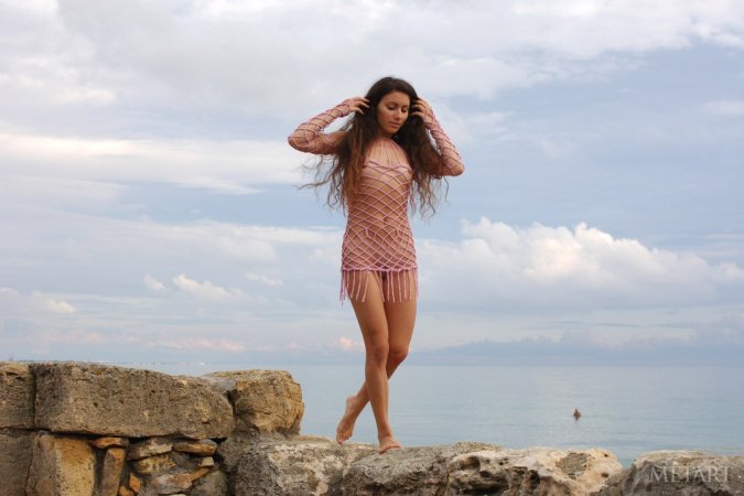 Woman with a pretty face is naked on the rocks photo 7