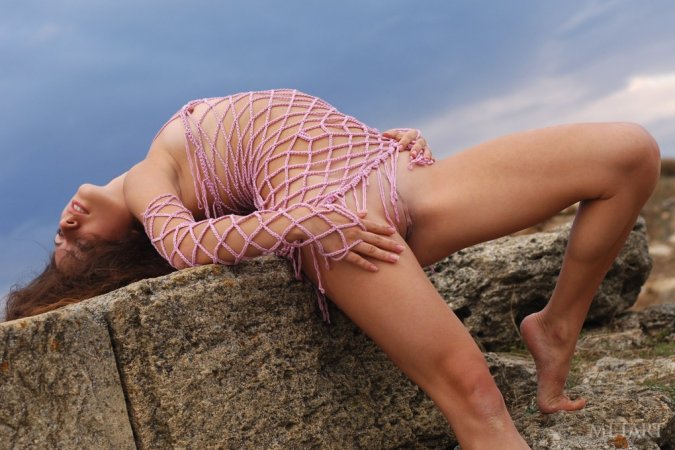 Woman with a pretty face is naked on the rocks photo 13