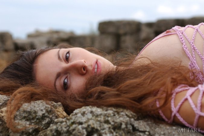 Woman with a pretty face is naked on the rocks photo 17