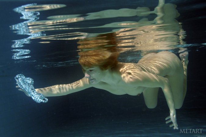 A redhead is dipping in the swimming pool photo 2