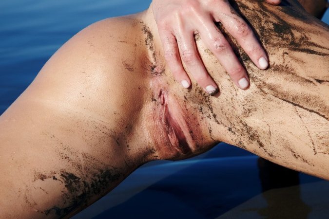 Blondie rubs herself with sand at the seaside. photo 3