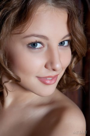 A curly brunette poses on the bed sheets photo 14
