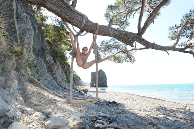 Teen is playing on a swing set by the beach photo 1