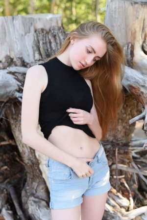 Naked babe gets her satisfaction on a log photo 16